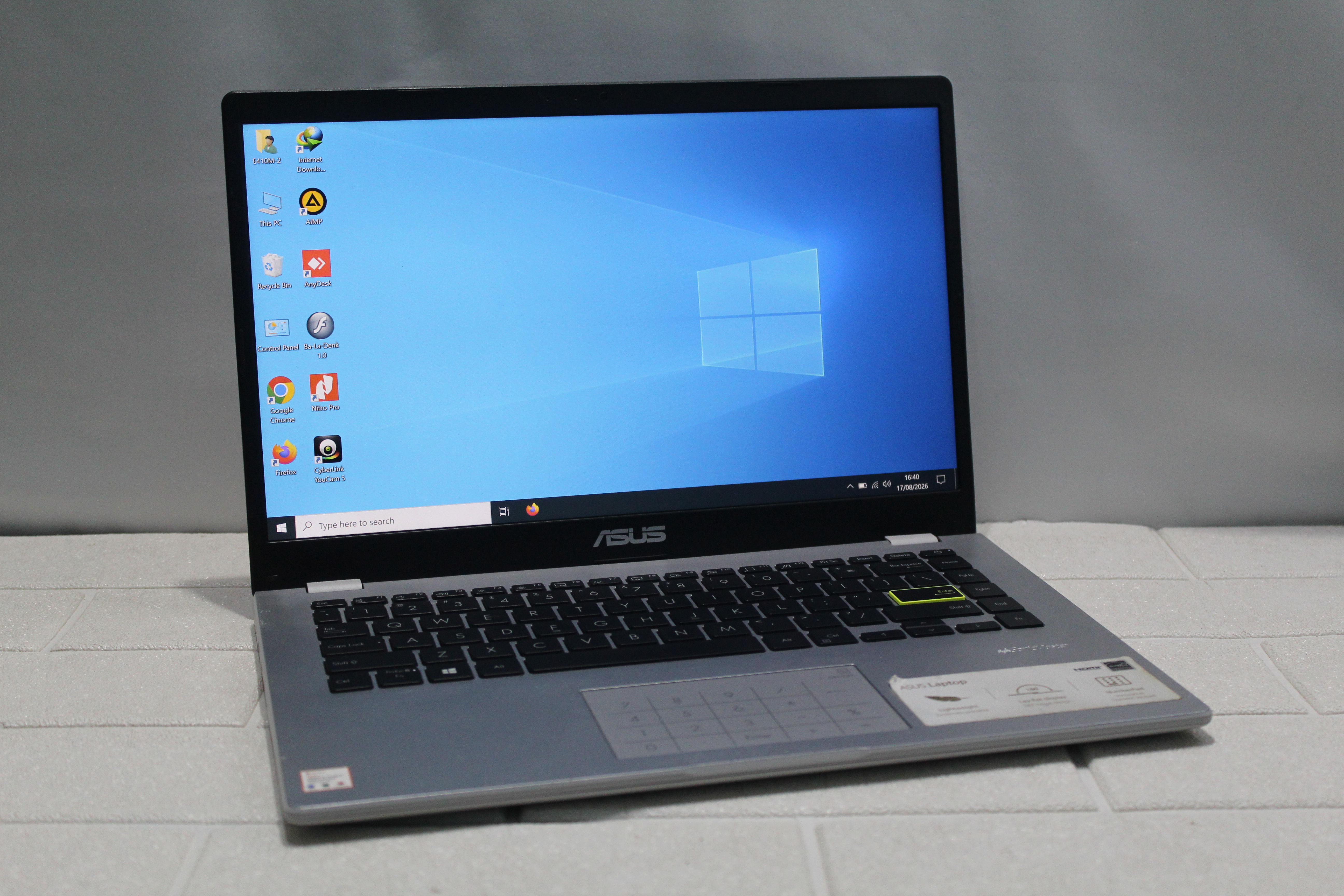 A sleek laptop and smartphone placed on wooden flooring, showcasing contemporary technology.