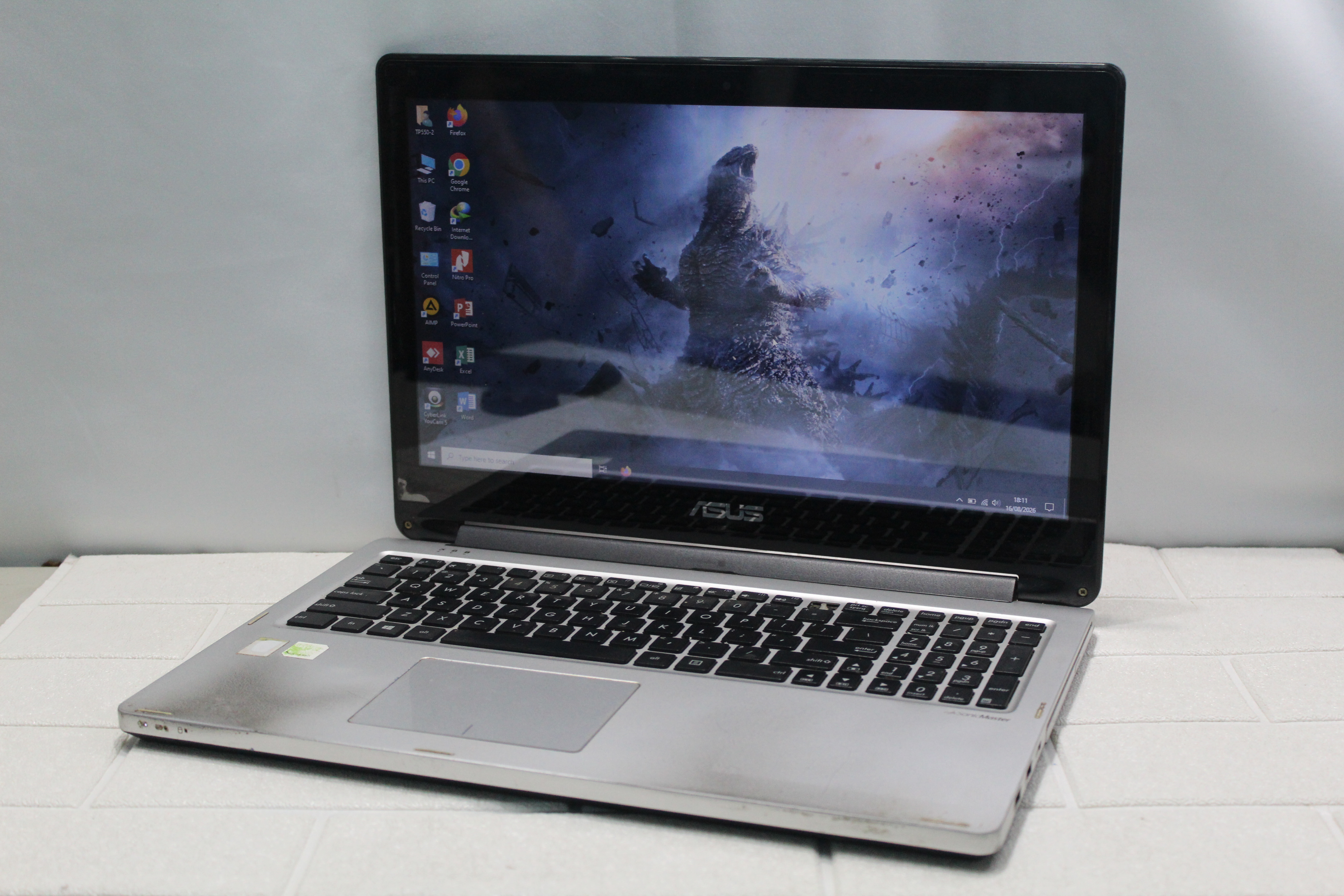 A sleek laptop and smartphone placed on wooden flooring, showcasing contemporary technology.