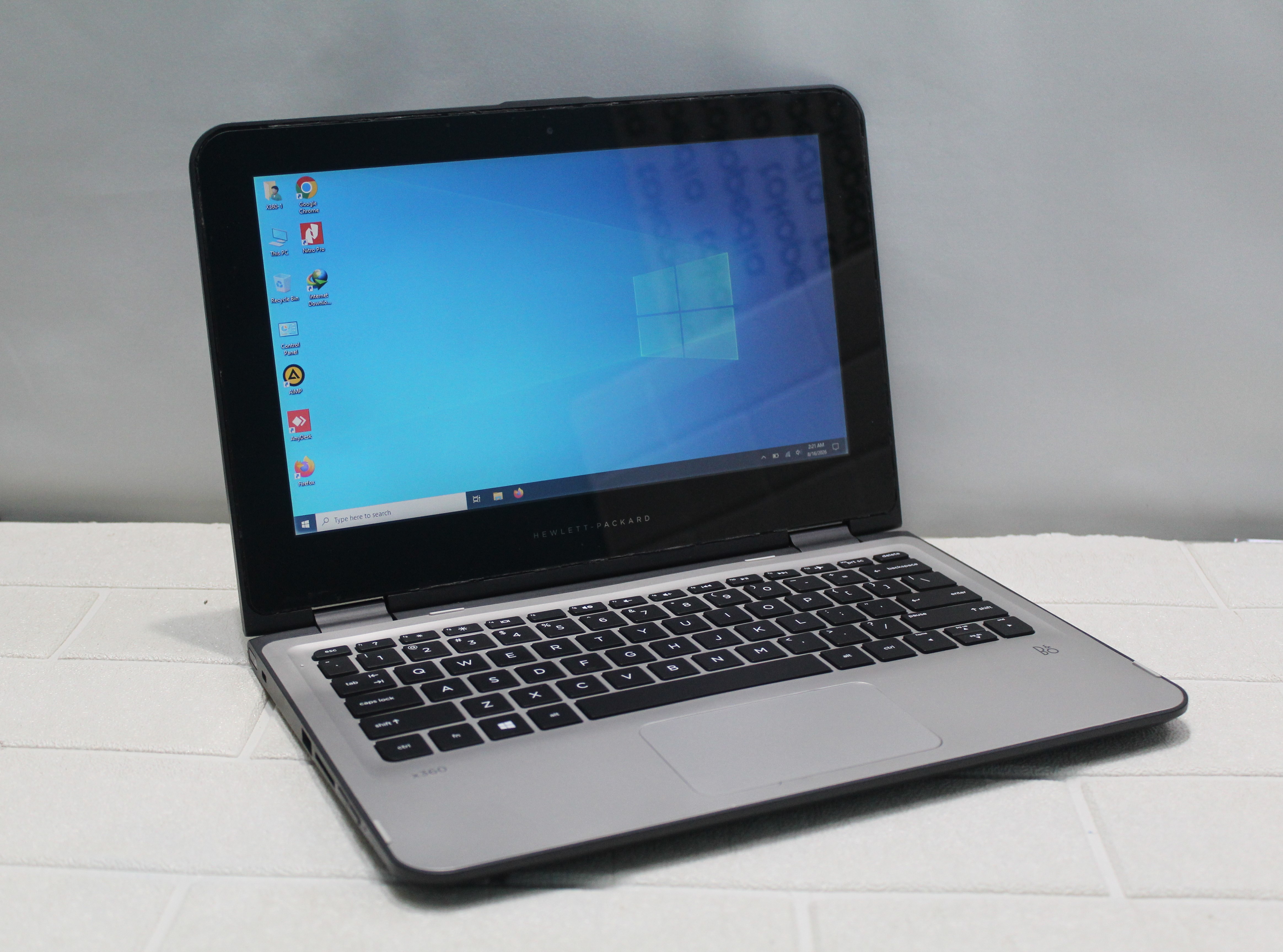A sleek laptop and smartphone placed on wooden flooring, showcasing contemporary technology.